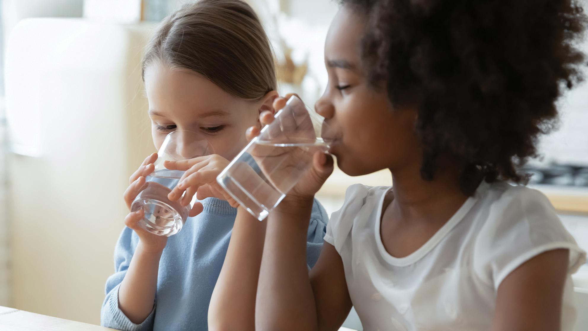 Children drinking water from glasses